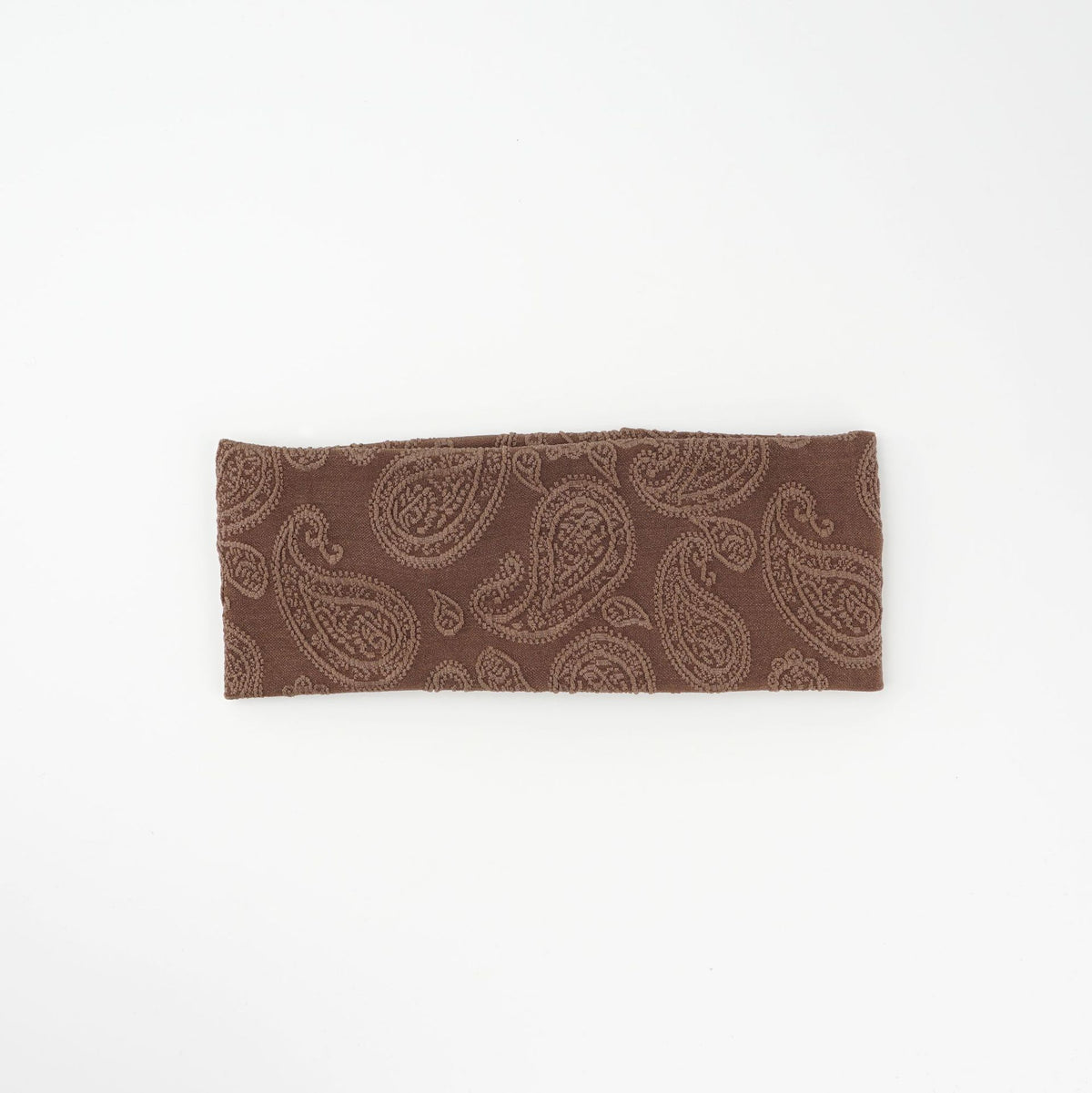 Wide knit headbands with a raised paisley pattern in ivory, coffee, and black